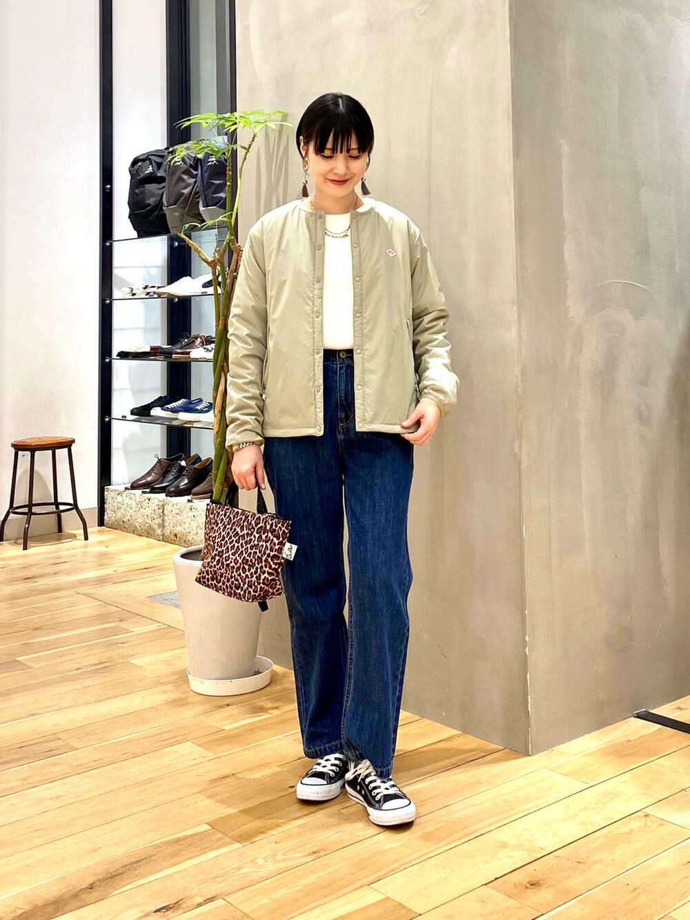 グリーン系のその他アウター、ホワイト系のニット/セーター、ブルー系のデニムパンツを着用したレディースの冬コーディネートの2枚目の写真