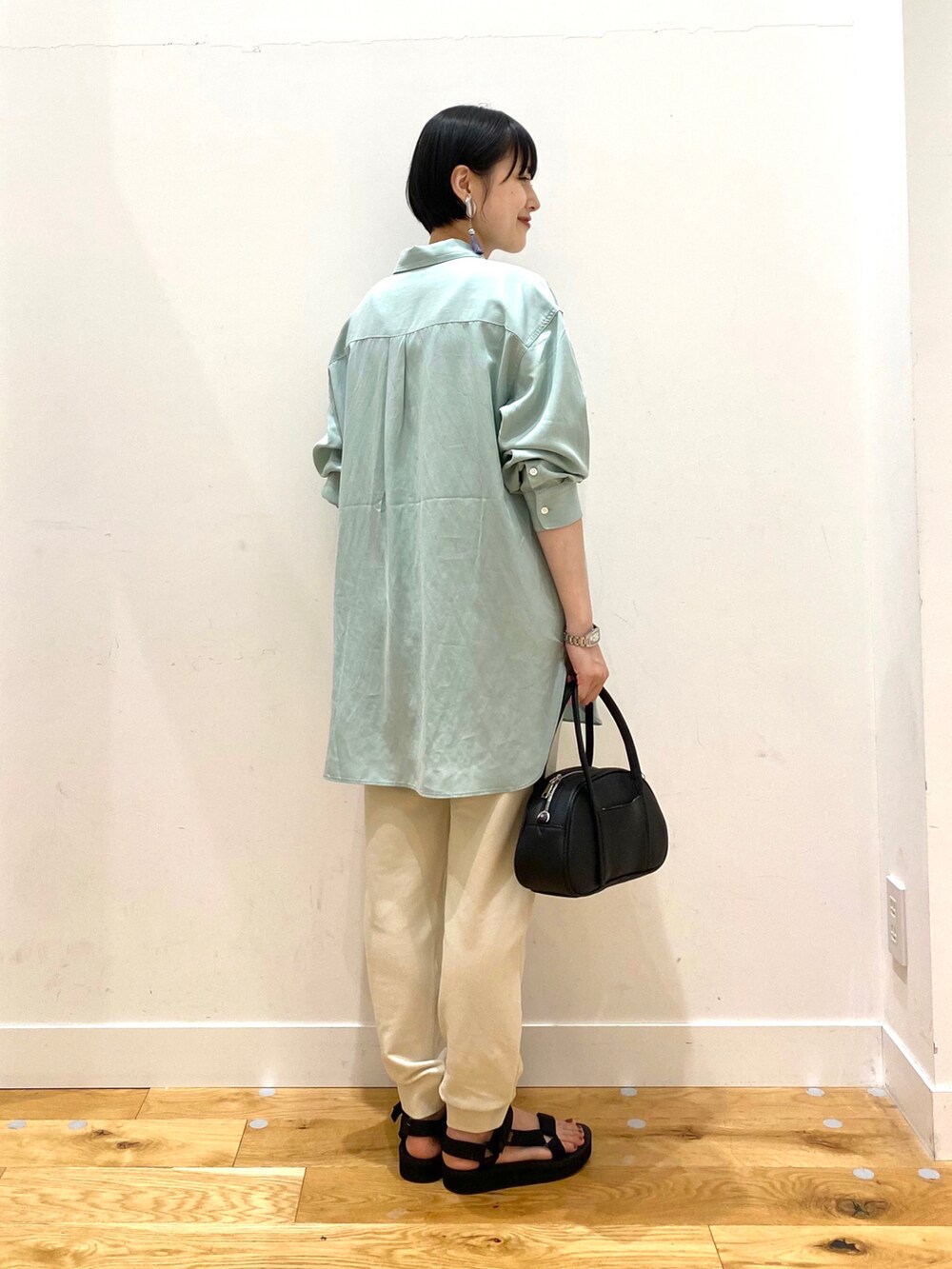 グリーン系のシャツ/ブラウス、ホワイト系のその他パンツ、ブラック系のショルダーバッグを着用したレディースの春コーディネートの3枚目の写真