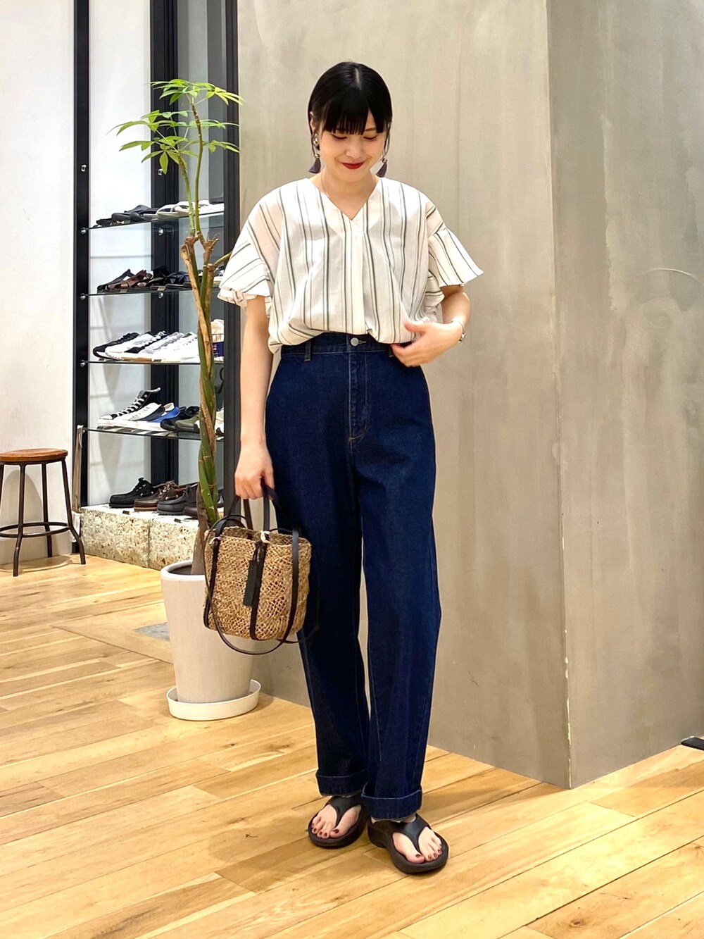 グリーン系のシャツ/ブラウス、ブルー系のデニムパンツ、ブラック系のサンダルを着用したレディースの春コーディネートの2枚目の写真