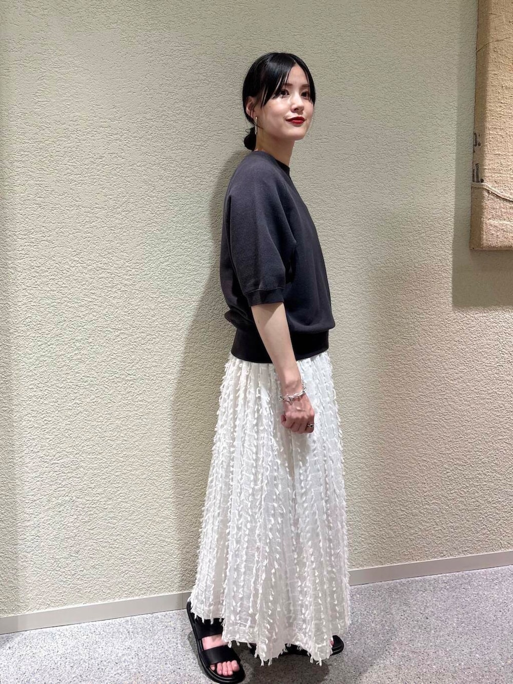 ホワイト系のスカート、グレー系のスウェットを着用したレディースの春コーディネートの2枚目の写真