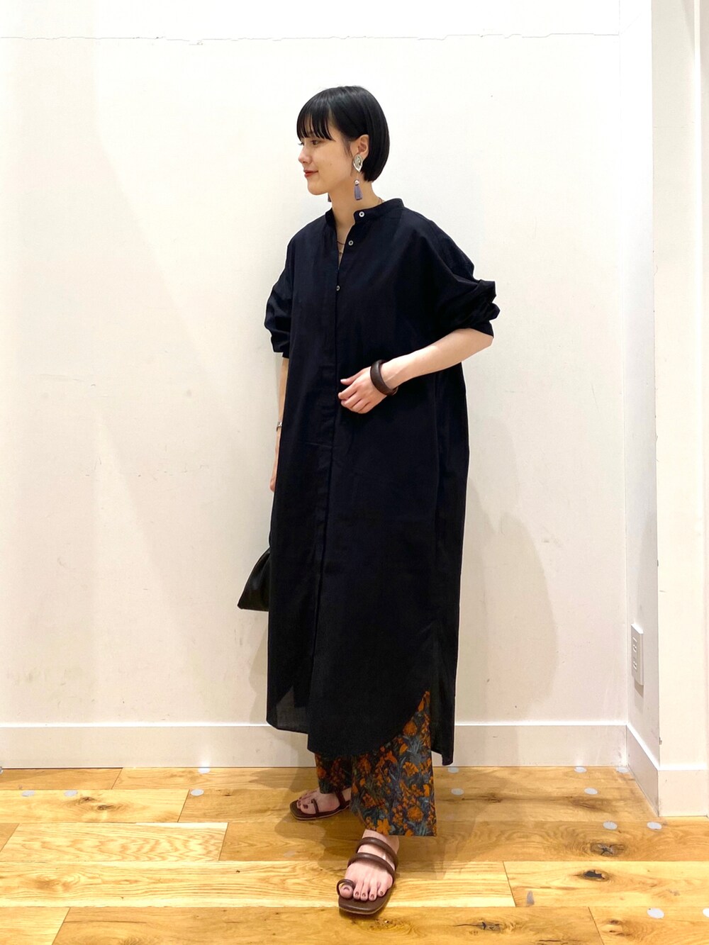 ブラック系のワンピース、オレンジ系のその他パンツ、ブラック系のショルダーバッグを着用したレディースの春コーディネートの2枚目の写真