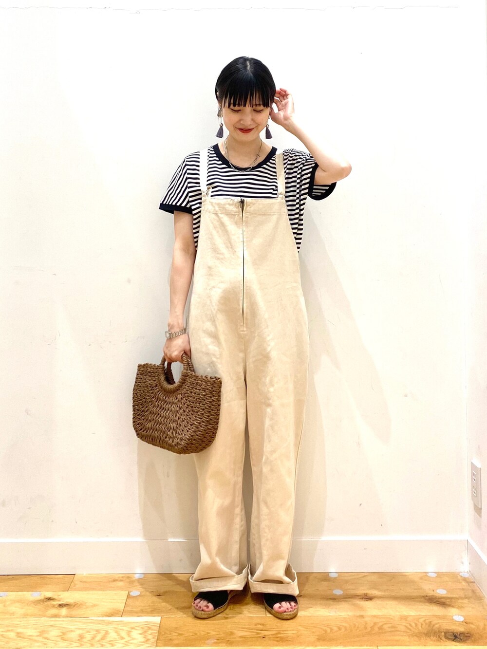 ホワイト系のTシャツ/カットソー、ホワイト系のサロペット/オーバーオール、ブラウン系のハンドバッグを着用したレディースの春コーディネートの2枚目の写真