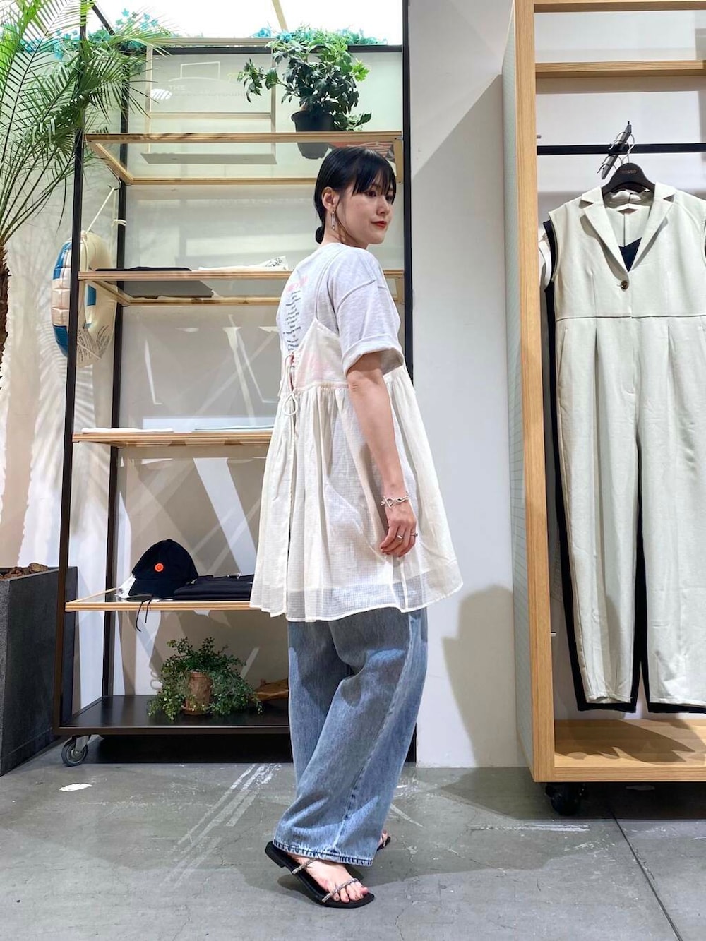 ブルー系のデニムパンツ、グレー系のTシャツ/カットソー、ブラック系のサンダルを着用したレディースの夏コーディネートの5枚目の写真