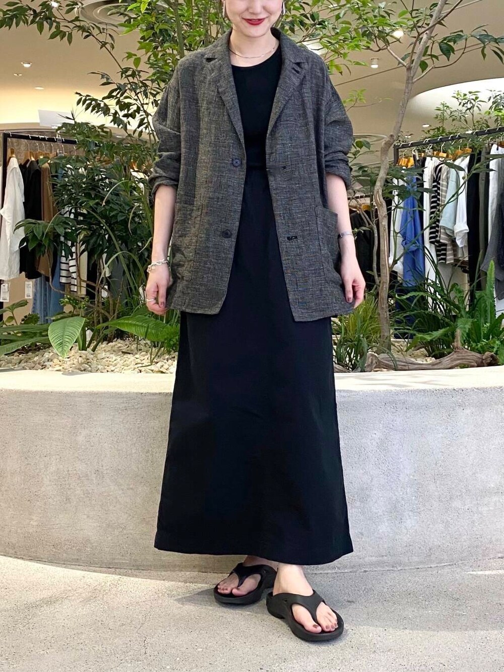 ブラック系のスカート、ブラック系のテーラードジャケット、ブラック系のタンクトップを着用したレディースの夏コーディネートの4枚目の写真