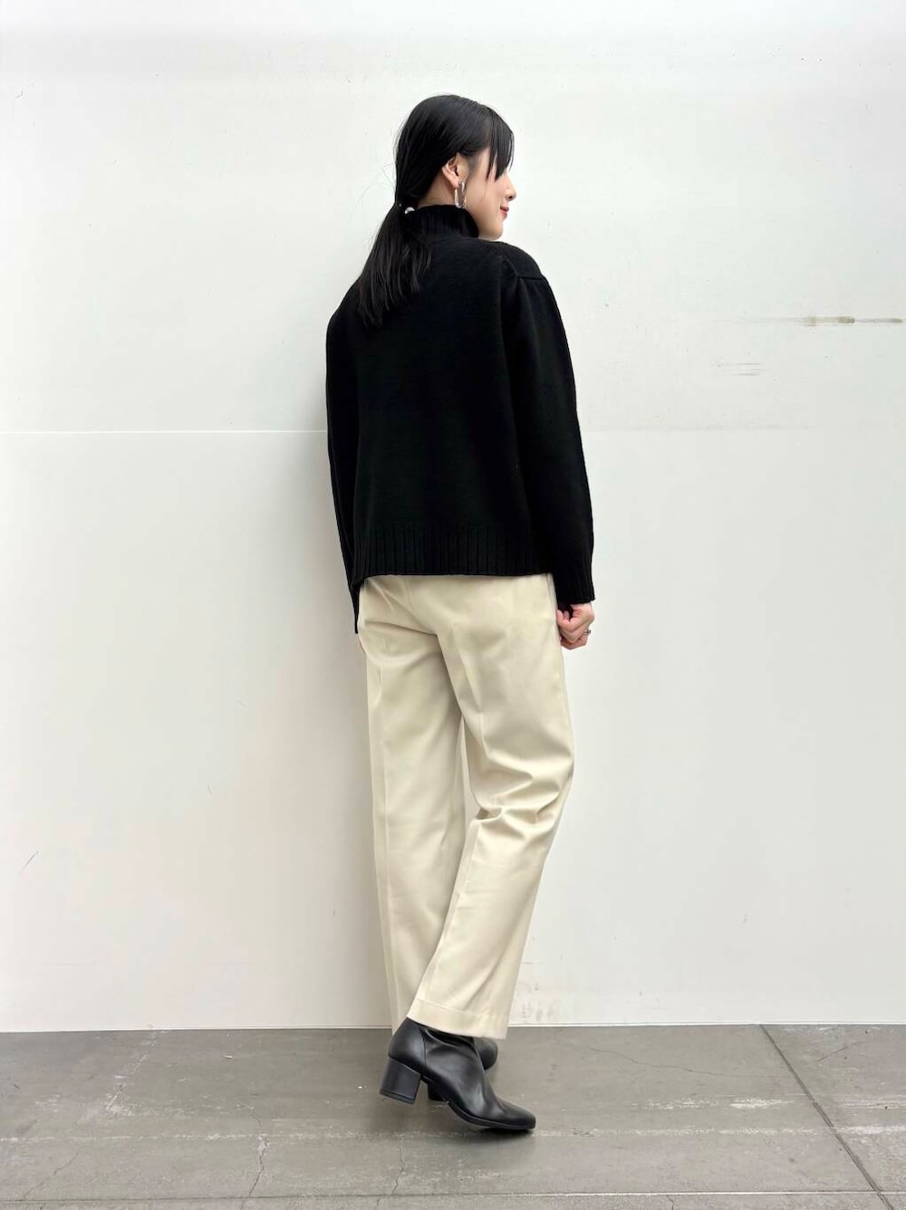 ブラック系のブーツ、イエロー系のステンカラーコート、ホワイト系のその他パンツを着用したレディースの冬コーディネートの6枚目の写真