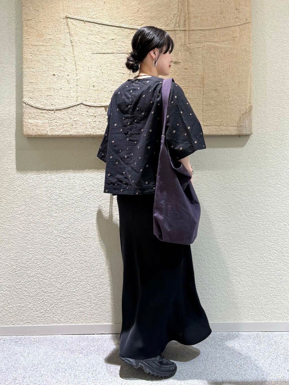 ブラック系のスカート、パープル系のトートバッグ、ブラック系のシャツ/ブラウスを着用したレディースの春コーディネートの3枚目の写真