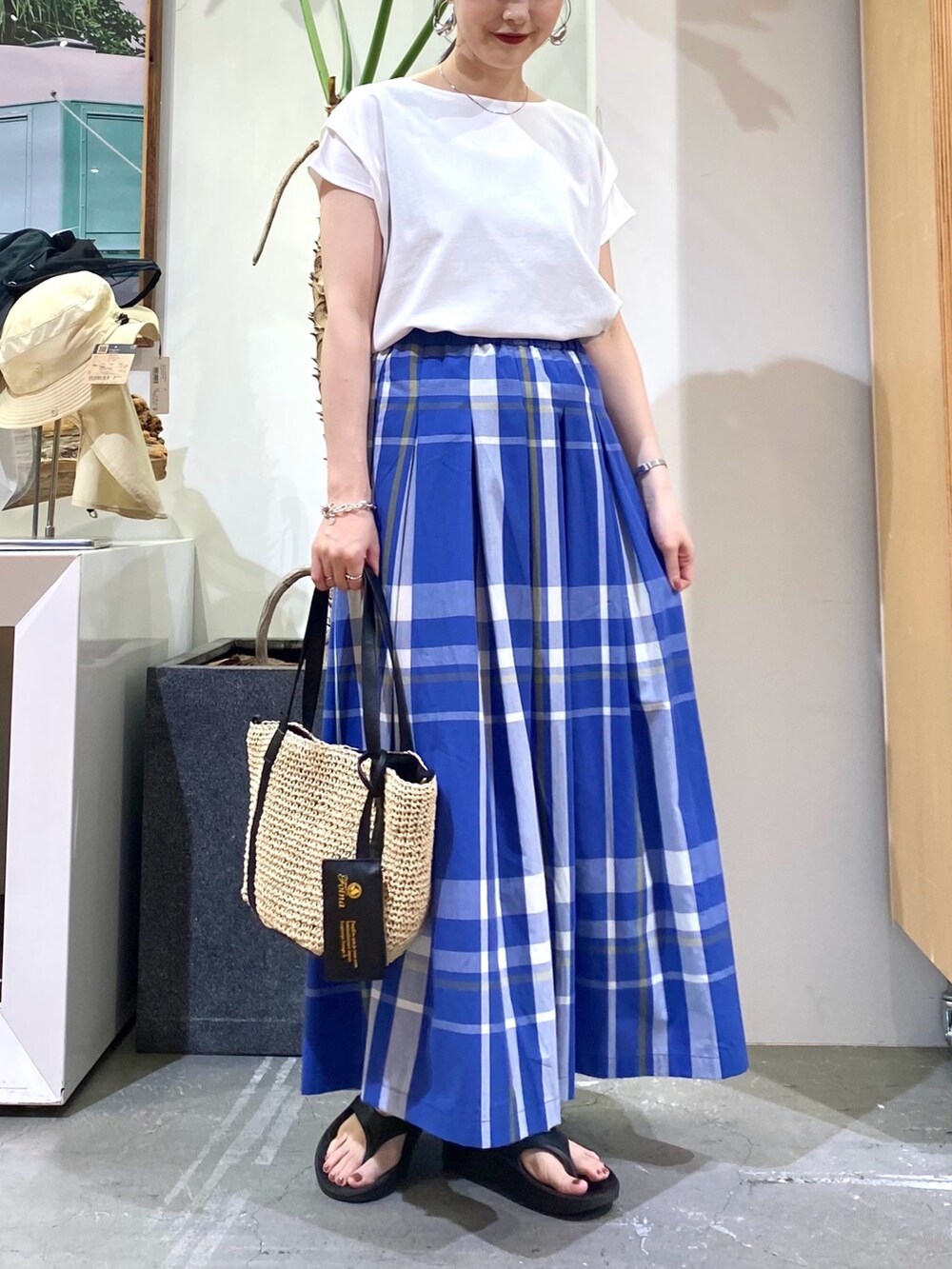 ホワイト系のTシャツ/カットソー、ブルー系のスカート、ベージュ系のトートバッグを着用したレディースの夏コーディネートの4枚目の写真