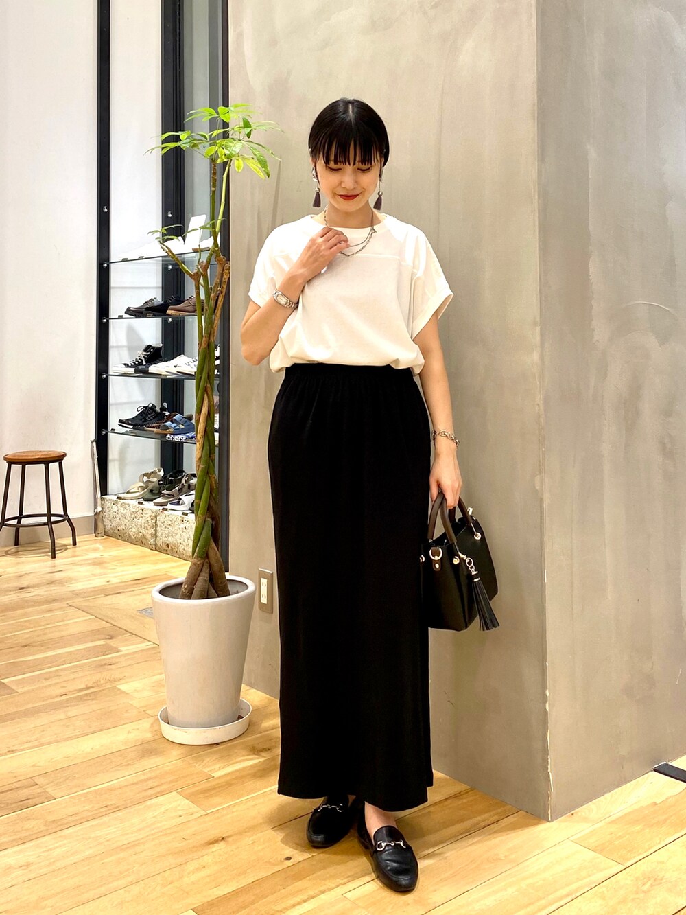 ブルー系のカーディガン/ボレロ、ホワイト系のTシャツ/カットソー、ブラック系のスカートを着用したレディースの秋コーディネートの3枚目の写真