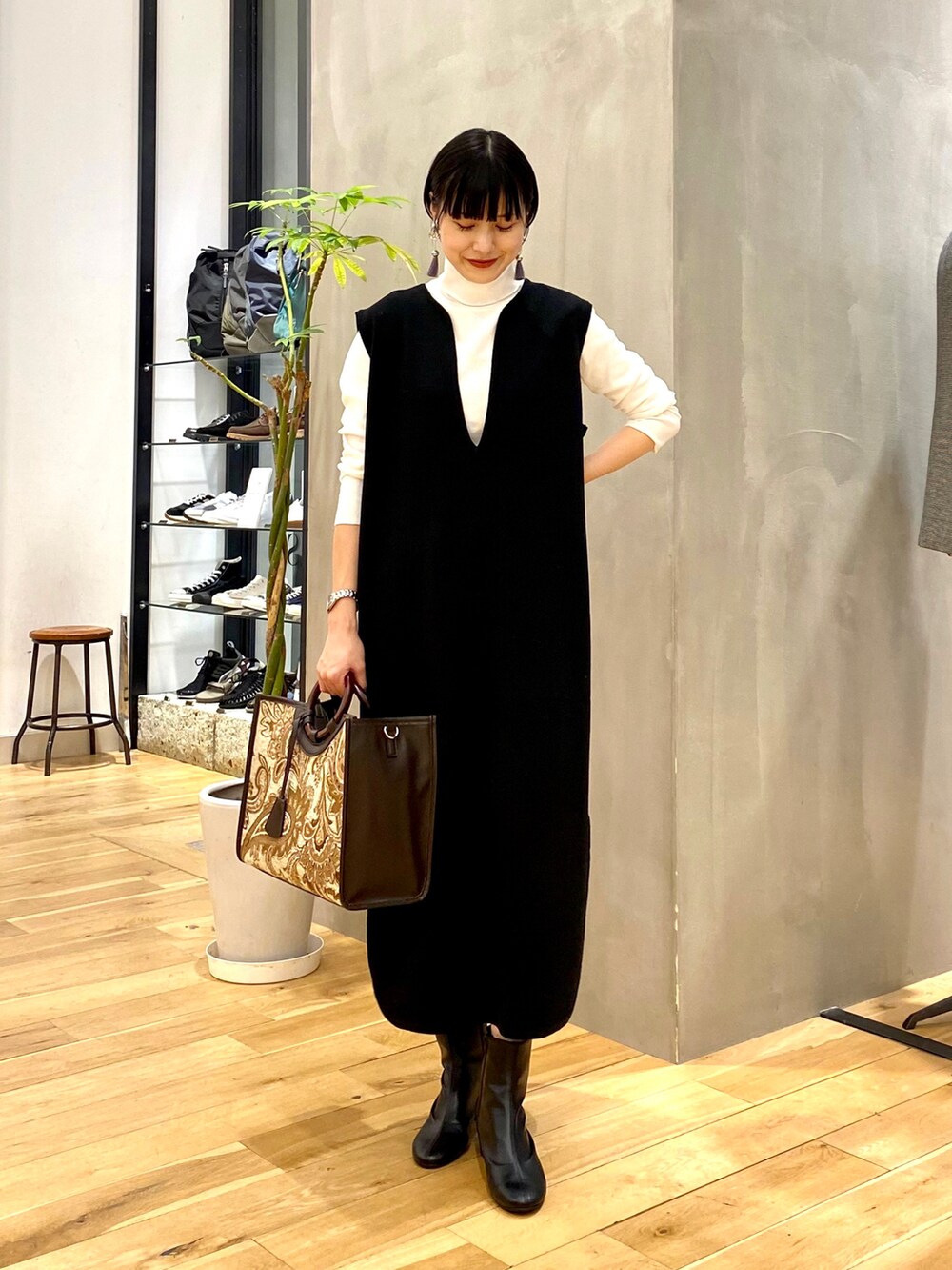 ホワイト系のTシャツ/カットソー、ブラック系のワンピース、ブラウン系のトートバッグを着用したレディースの秋コーディネートの2枚目の写真