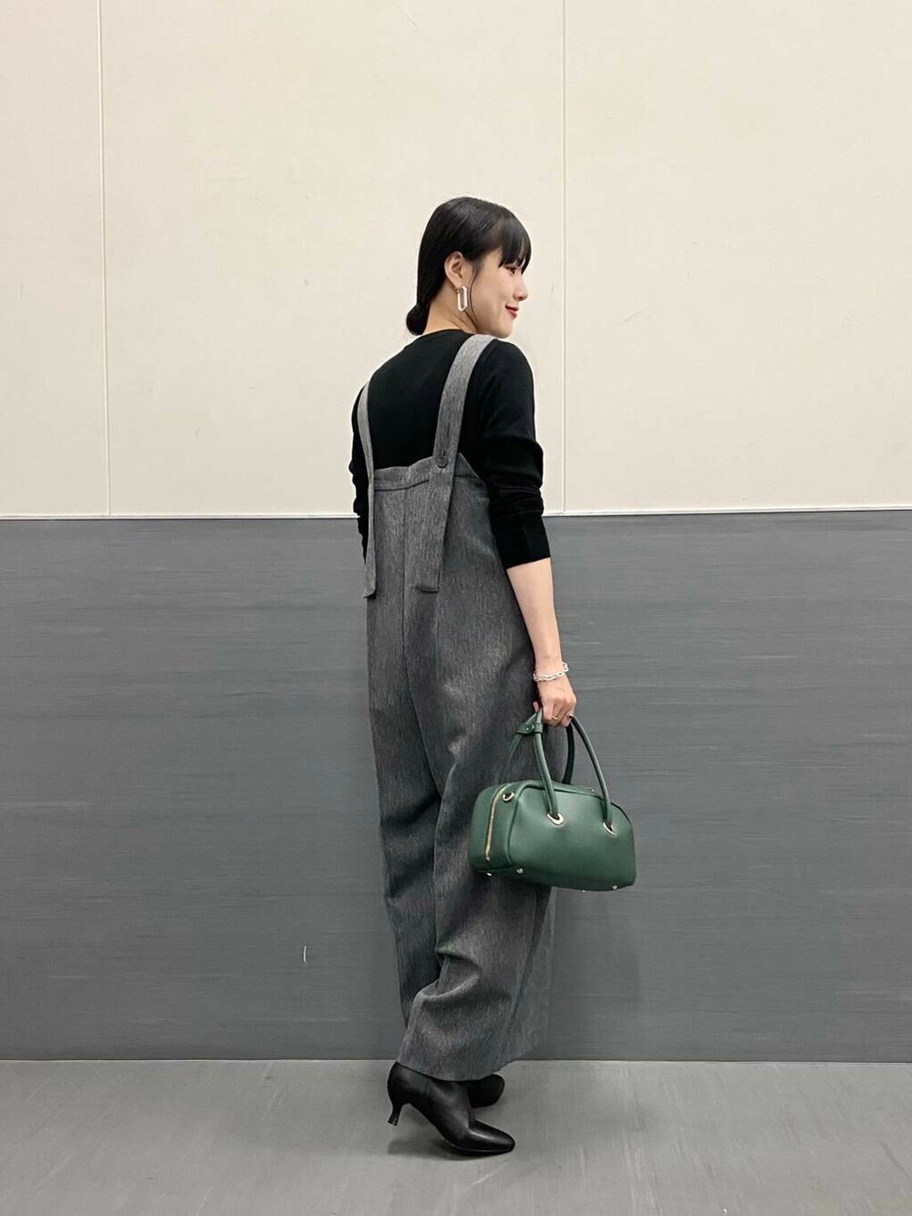 ブラック系のTシャツ/カットソー、グレー系のサロペット/オーバーオール、ブラック系のブーツを着用したレディースの秋コーディネートの3枚目の写真