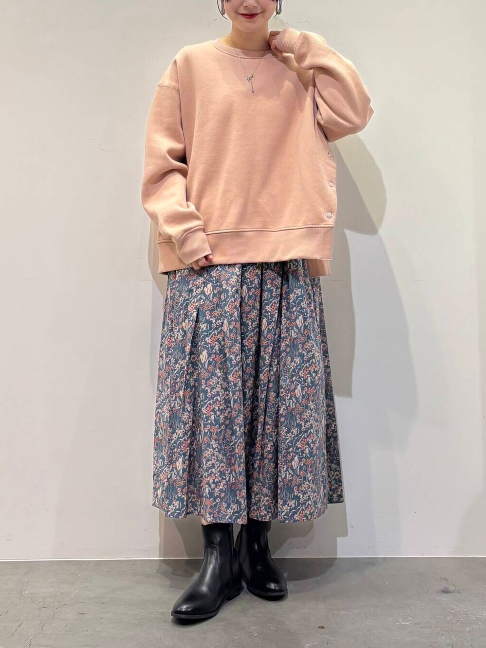 ブラック系のブーツ、ブルー系のスカート、ピンク系のスウェットを着用したレディースの冬コーディネートの4枚目の写真