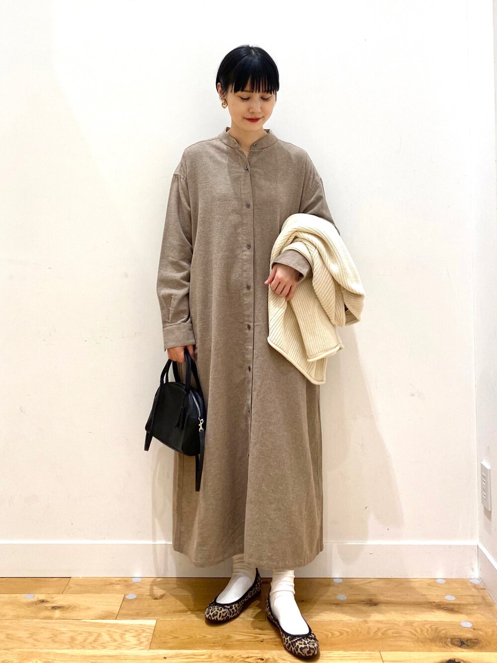 ホワイト系のカーディガン/ボレロ、ベージュ系のワンピース、ブラック系のボストンバッグを着用したレディースの冬コーディネートの4枚目の写真