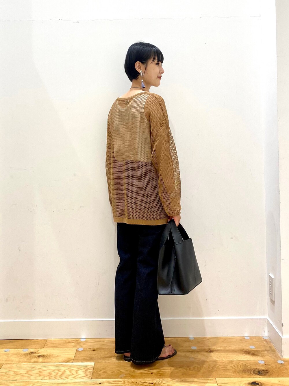 ブラウン系のニット/セーター、ホワイト系のタンクトップ、ブルー系のデニムパンツを着用したレディースの夏コーディネートの3枚目の写真