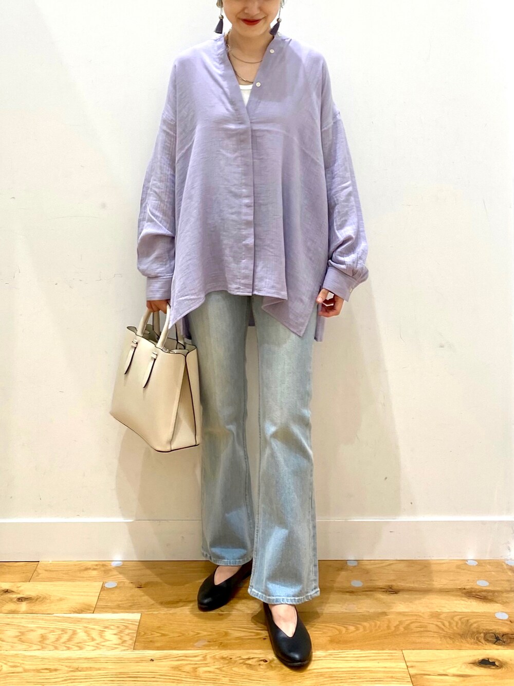 パープル系のシャツ/ブラウス、ブルー系のデニムパンツ、ホワイト系のトートバッグを着用したレディースの秋コーディネートの4枚目の写真