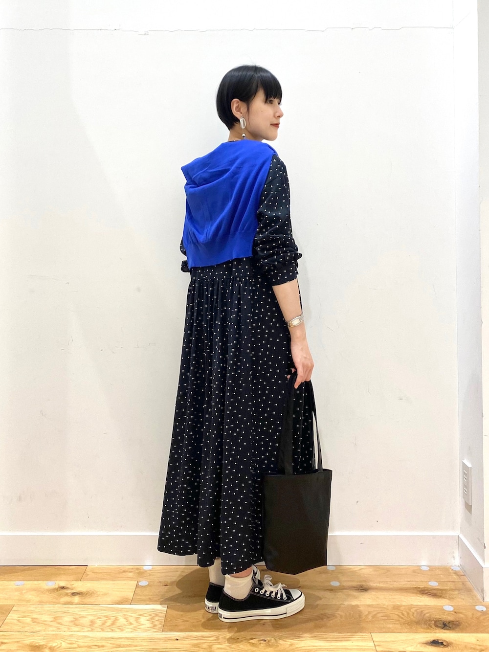 ブラック系のワンピース、ブルー系のカーディガン/ボレロ、ブラック系のトートバッグを着用したレディースの春コーディネートの3枚目の写真