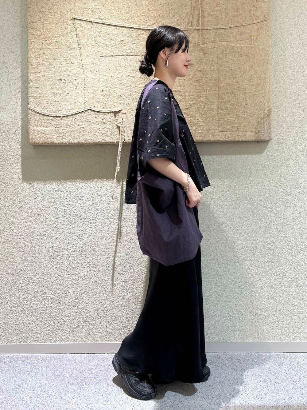 ブラック系のスカート、パープル系のトートバッグ、ブラック系のシャツ/ブラウスを着用したレディースの春コーディネートの2枚目の写真