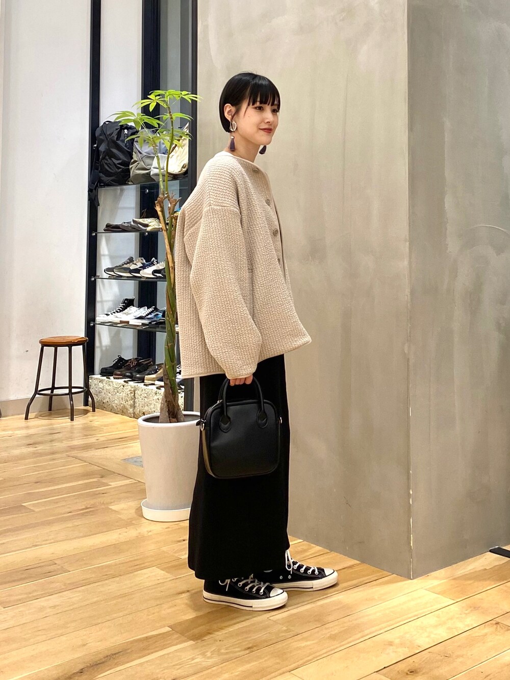 グレー系のノーカラージャケット、ホワイト系のTシャツ/カットソー、ブラック系のスカートを着用したレディースの春コーディネートの2枚目の写真