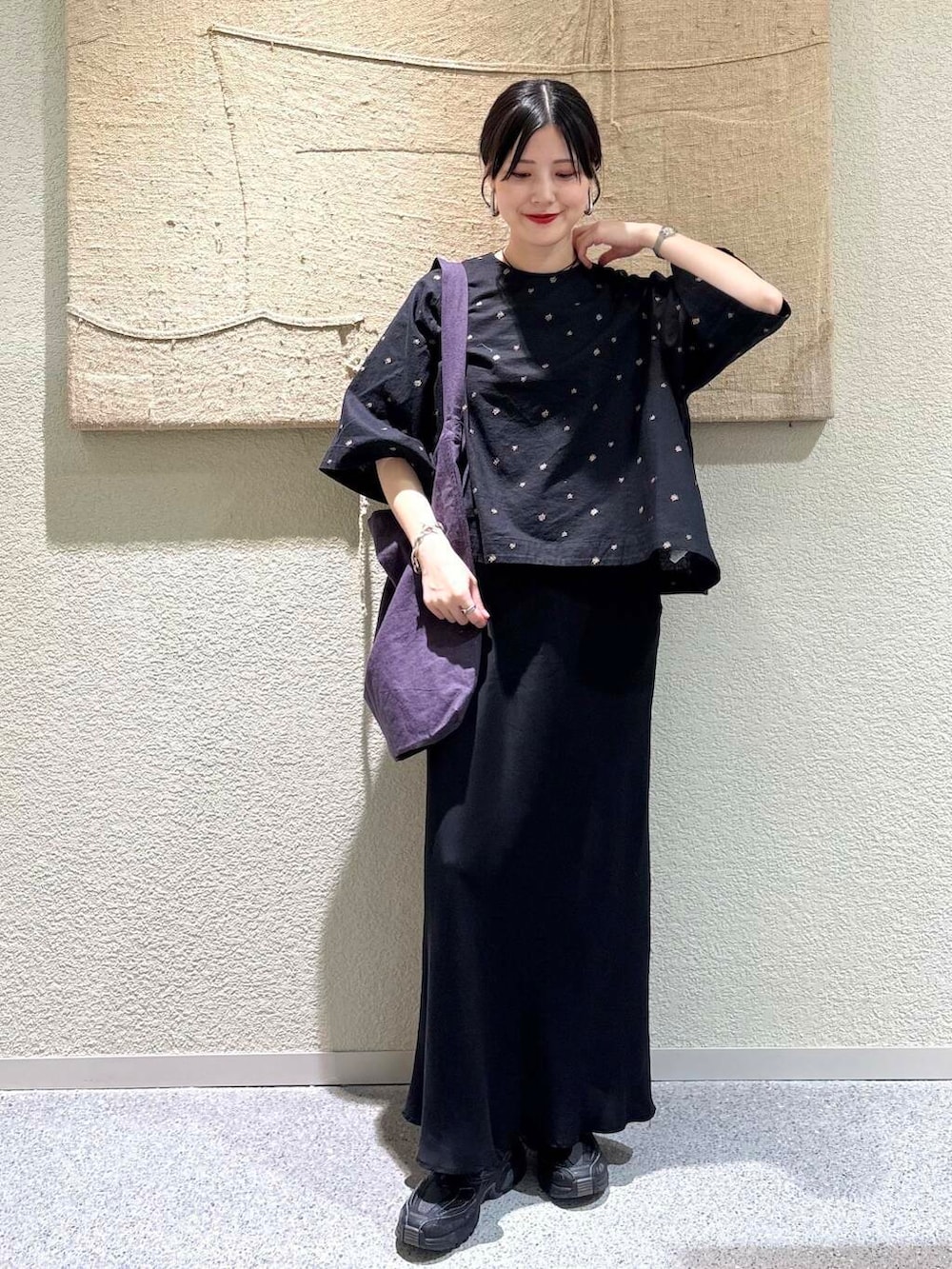 ブラック系のスカート、パープル系のトートバッグ、ブラック系のシャツ/ブラウスを着用したレディースの春コーディネートの6枚目の写真