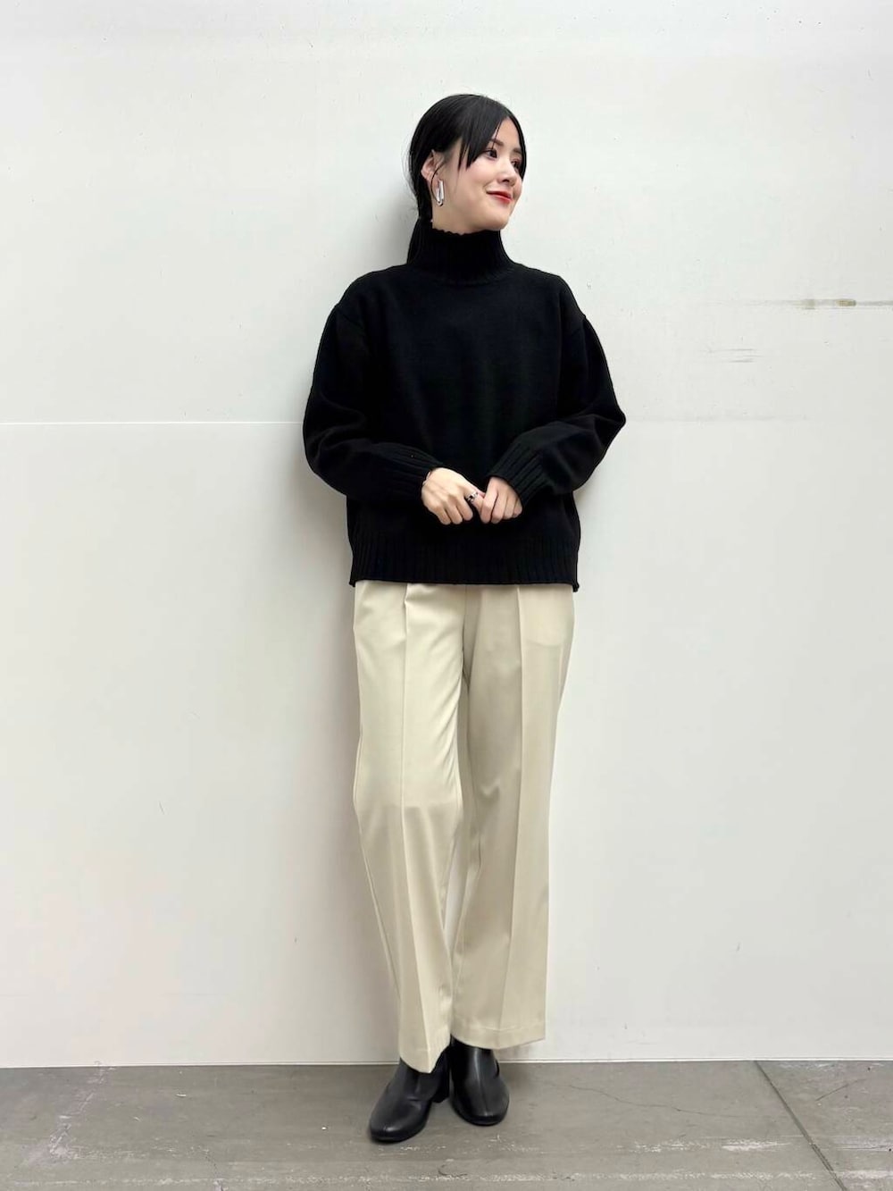 ブラック系のブーツ、イエロー系のステンカラーコート、ホワイト系のその他パンツを着用したレディースの冬コーディネートの4枚目の写真