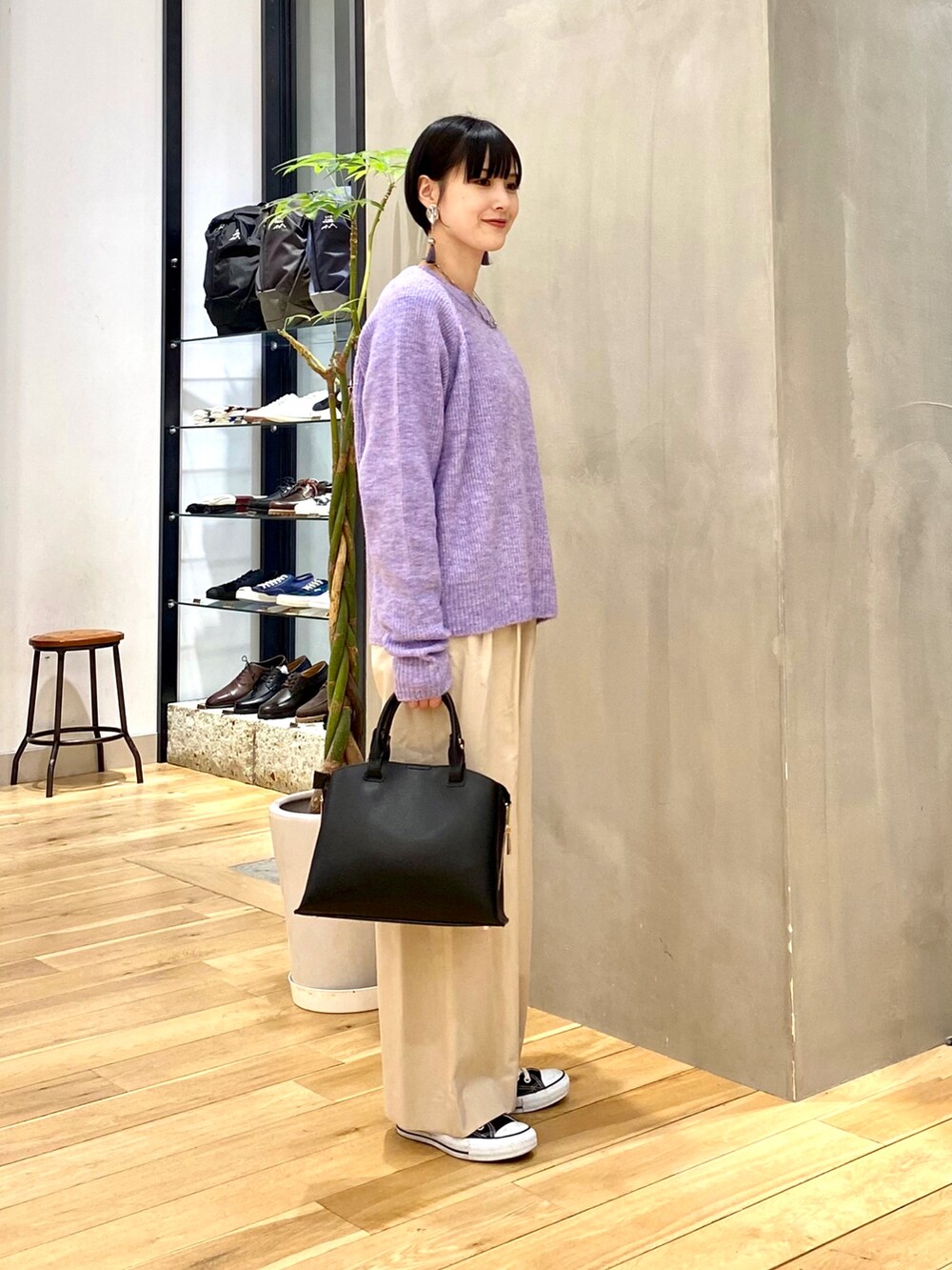 パープル系のニット/セーター、ホワイト系のその他パンツ、ブラック系のトートバッグを着用したレディースの冬コーディネートの3枚目の写真