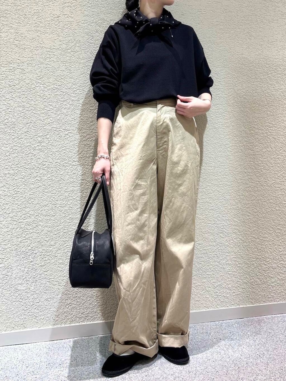 ブラック系のニット/セーター、ベージュ系のその他パンツ、ブラック系のバンダナ/スカーフを着用したレディースの春コーディネートの4枚目の写真