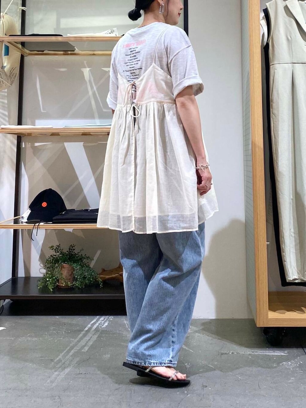 ブルー系のデニムパンツ、グレー系のTシャツ/カットソー、ブラック系のサンダルを着用したレディースの夏コーディネートの8枚目の写真