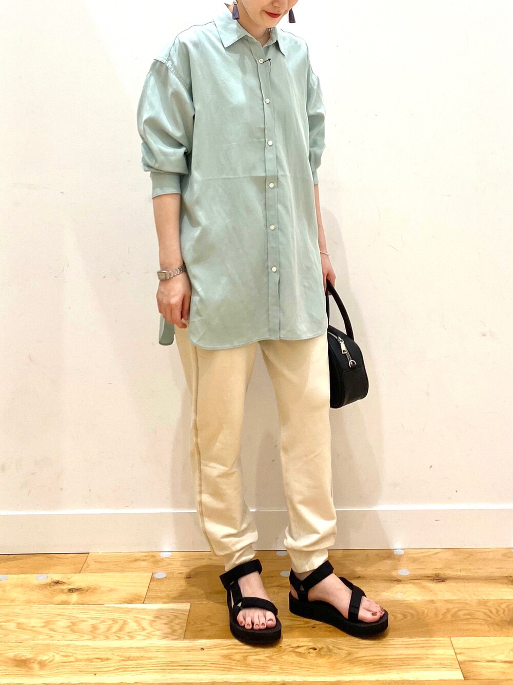 グリーン系のシャツ/ブラウス、ホワイト系のその他パンツ、ブラック系のショルダーバッグを着用したレディースの春コーディネートの5枚目の写真