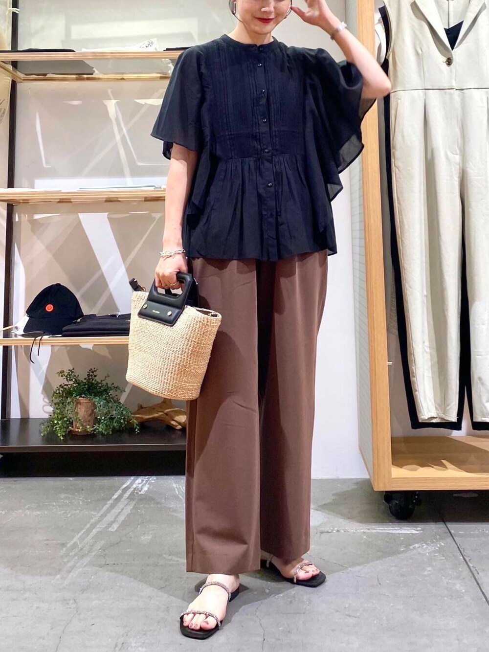 ベージュ系のハンドバッグ、ブラック系のサンダル、ブラック系のシャツ/ブラウスを着用したレディースの夏コーディネートの6枚目の写真