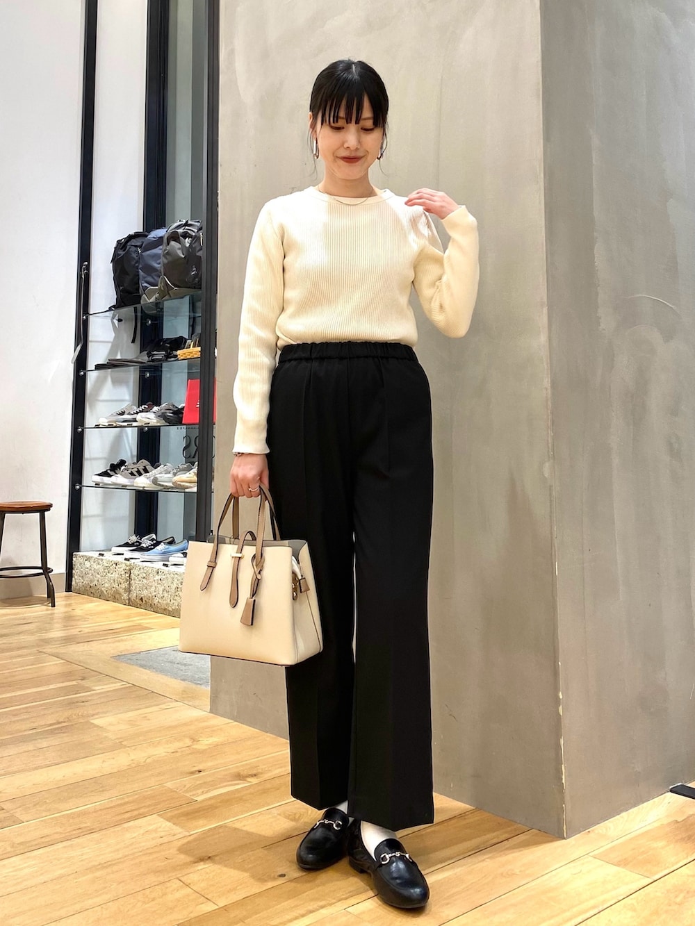 ホワイト系のニット/セーター、ブラック系のその他パンツ、ホワイト系のトートバッグを着用したレディースの冬コーディネートの5枚目の写真
