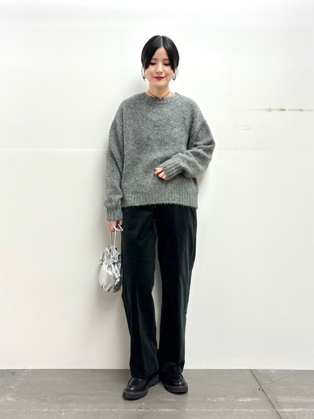 グレー系のニット/セーター、ブラック系のその他パンツ、シルバー系のショルダーバッグを着用したレディースの冬コーディネートの3枚目の写真