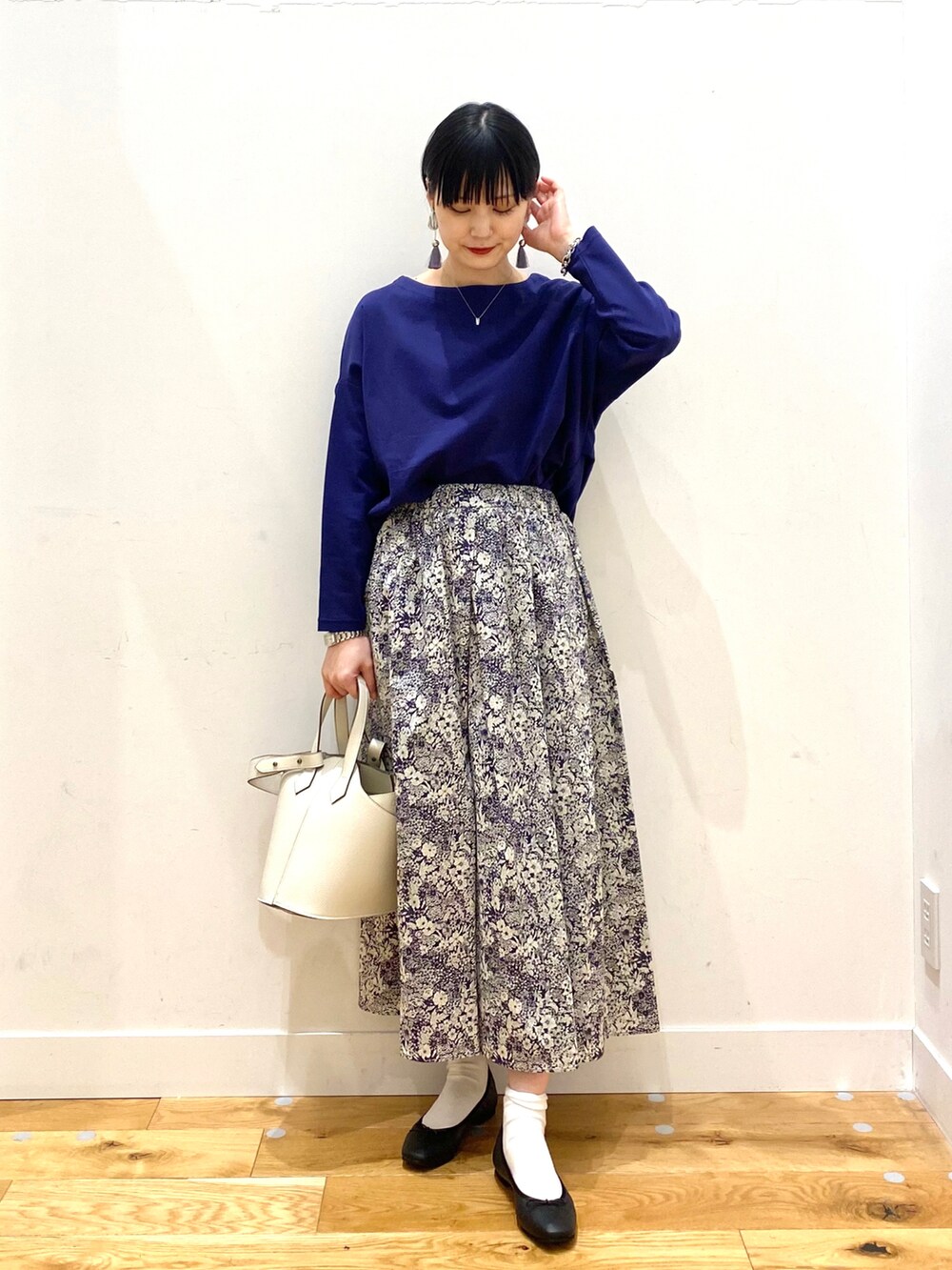 ブルー系のTシャツ/カットソー、ブルー系のスカート、ホワイト系のショルダーバッグを着用したレディースの春コーディネートの2枚目の写真