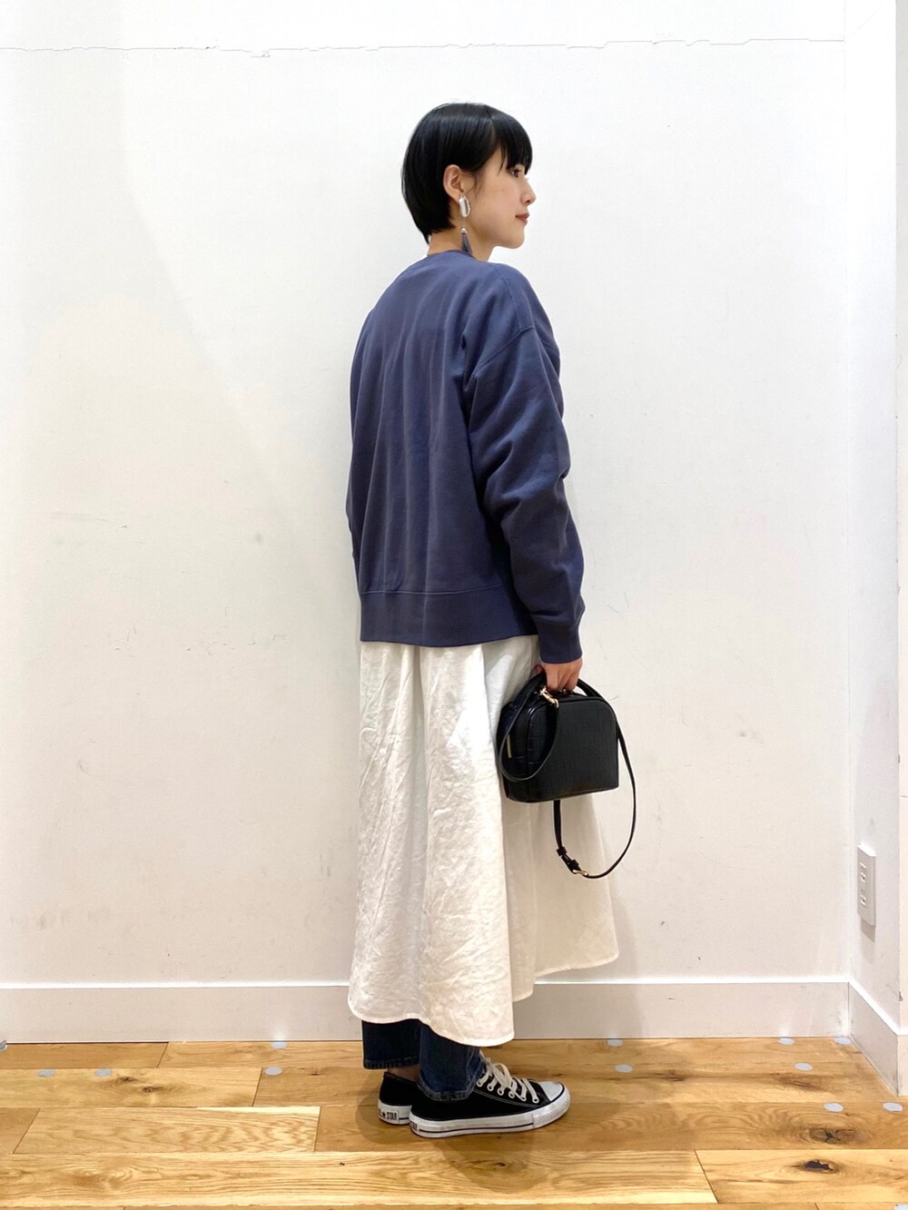 ブラック系のダウンジャケット/コート、ブルー系のスウェット、ホワイト系のワンピースを着用したレディースの冬コーディネートの5枚目の写真