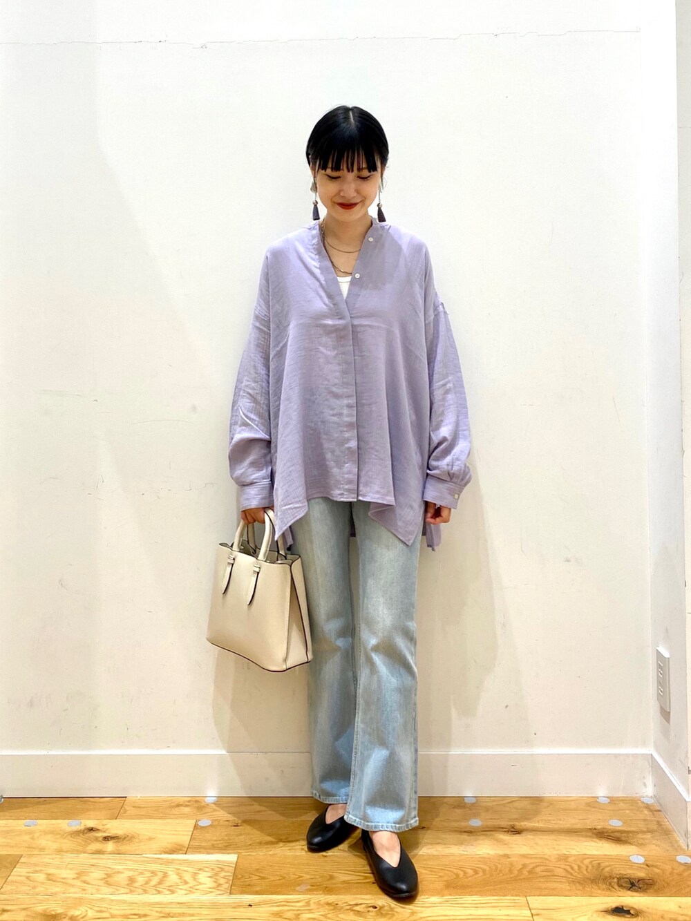 パープル系のシャツ/ブラウス、ブルー系のデニムパンツ、ホワイト系のトートバッグを着用したレディースの秋コーディネートの2枚目の写真