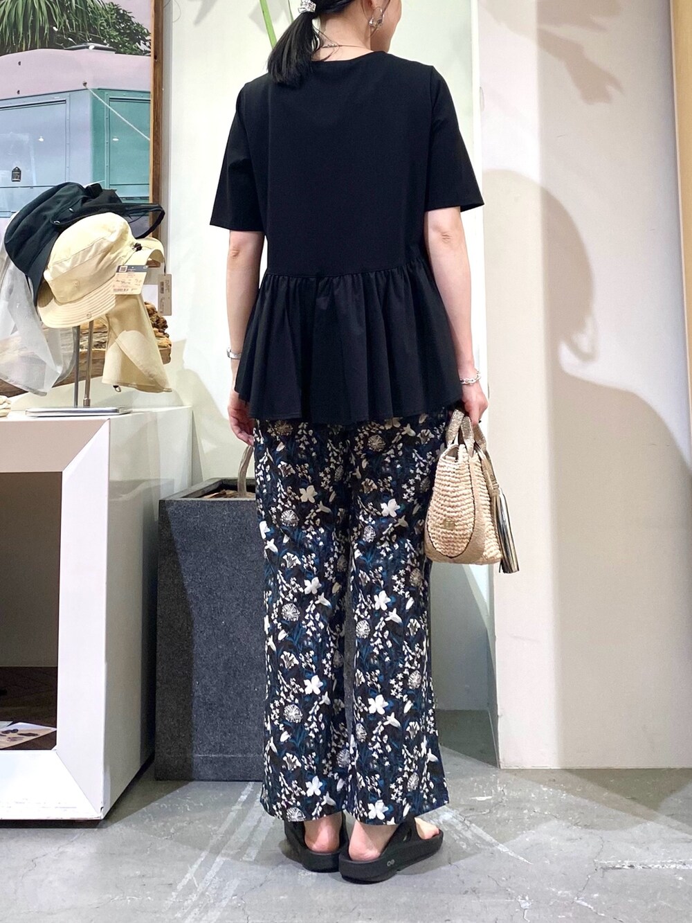 ブラック系のTシャツ/カットソー、ブルー系のその他パンツ、ゴールド系のかごバッグを着用したレディースの夏コーディネートの5枚目の写真