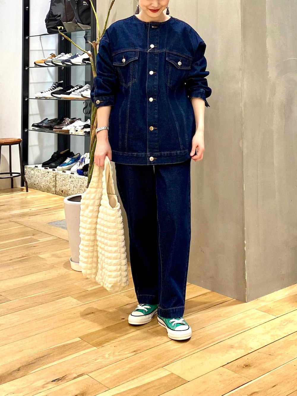 ブルー系のデニムジャケット、ブルー系のデニムパンツ、ホワイト系のトートバッグを着用したレディースの冬コーディネートの4枚目の写真