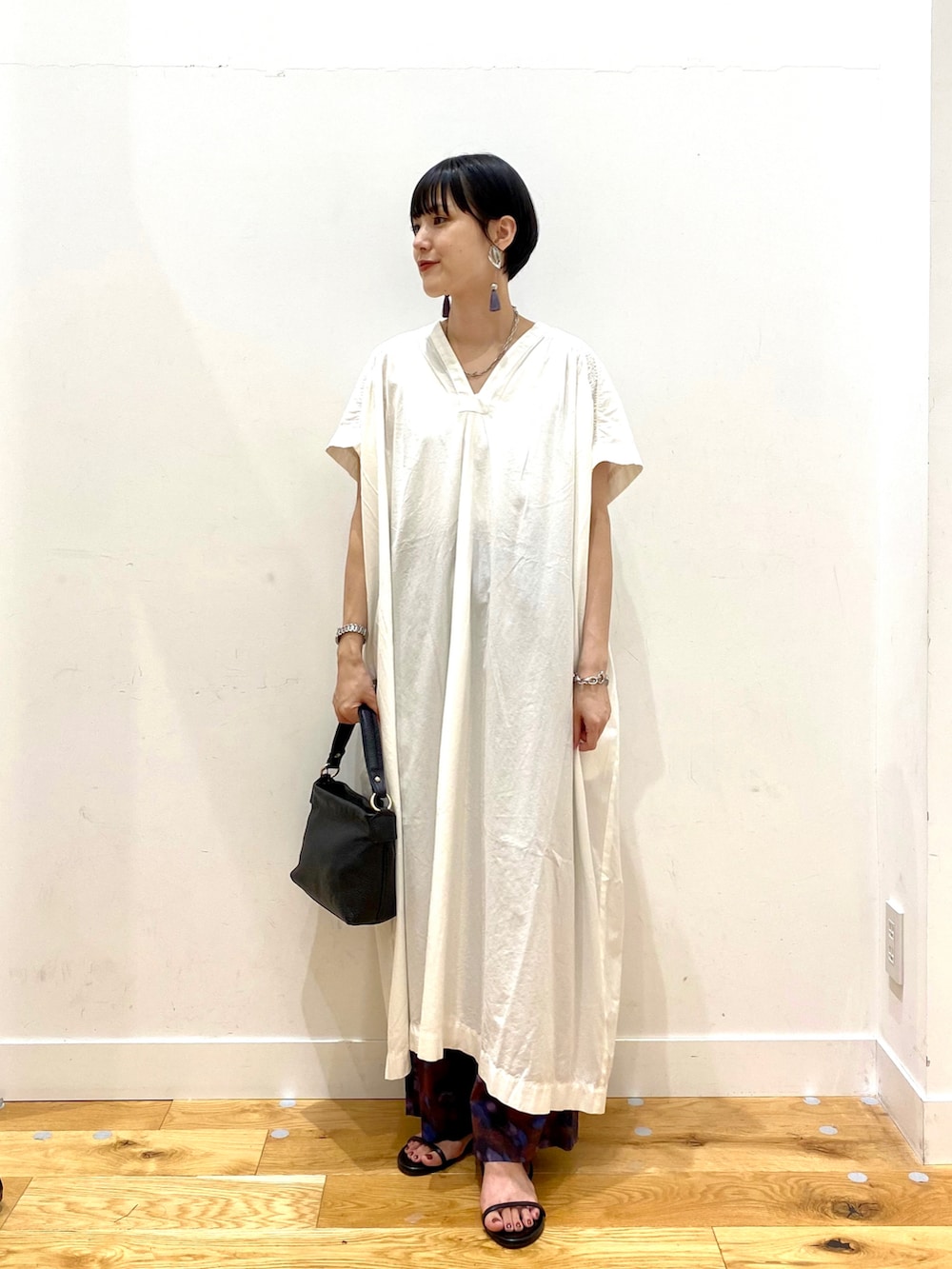 ホワイト系のワンピース、パープル系のその他パンツ、ブラック系のハンドバッグを着用したレディースの夏コーディネートの2枚目の写真