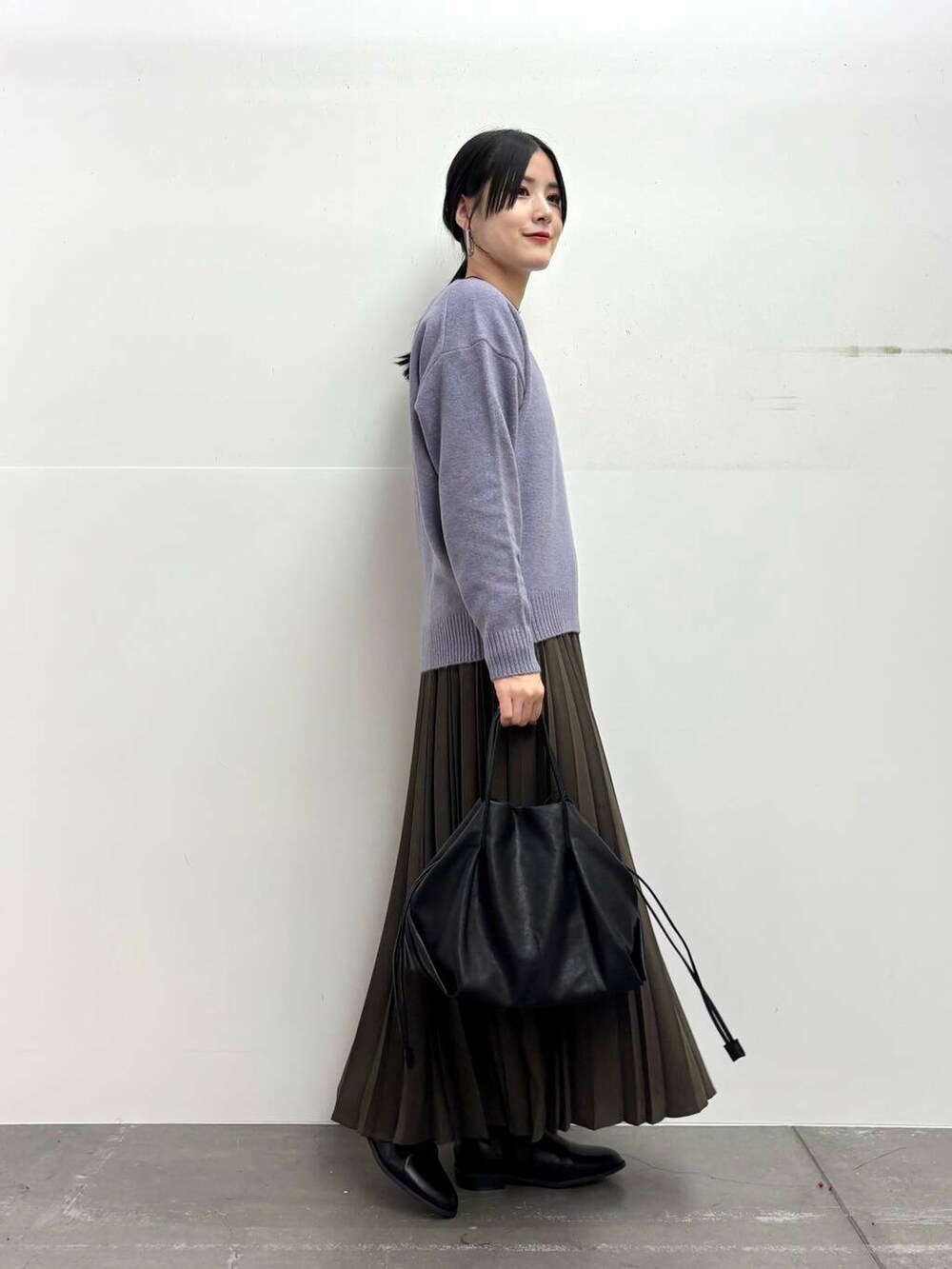 ブラック系のショルダーバッグ、ホワイト系のダウンジャケット/コート、ブラック系のブーツを着用したレディースの冬コーディネートの5枚目の写真