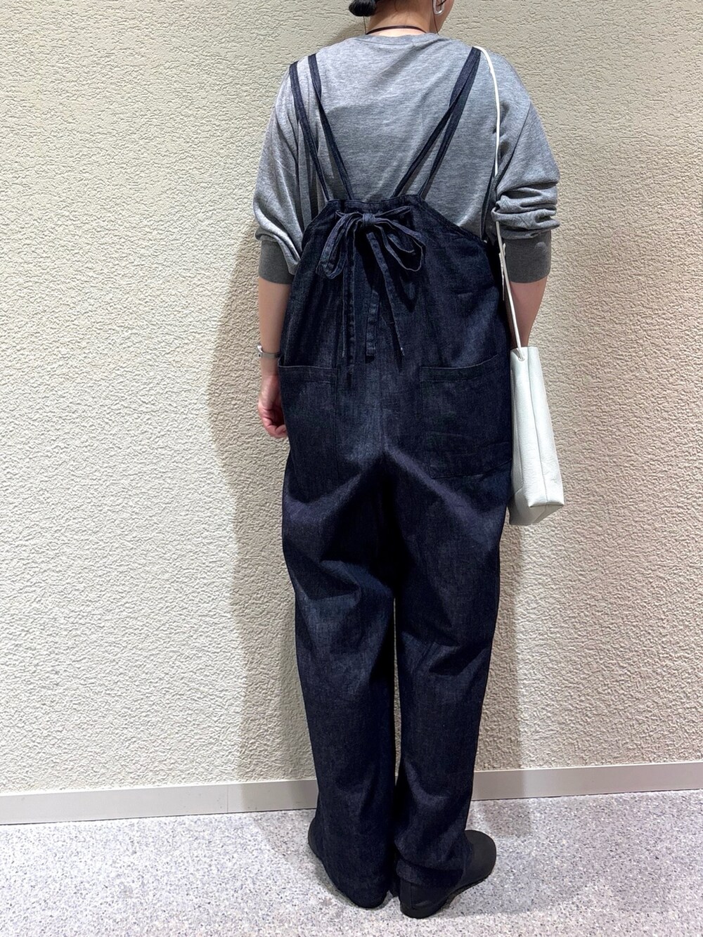 グレー系のニット/セーター、ブルー系のサロペット/オーバーオール、ホワイト系のショルダーバッグを着用したレディースの秋コーディネートの5枚目の写真