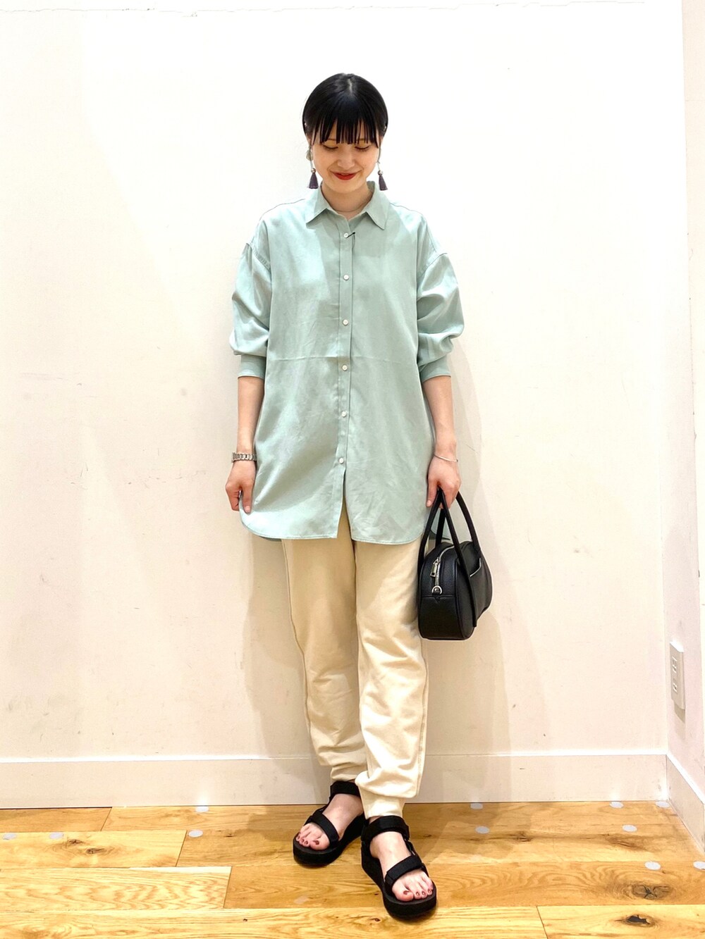 グリーン系のシャツ/ブラウス、ホワイト系のその他パンツ、ブラック系のショルダーバッグを着用したレディースの春コーディネートの2枚目の写真
