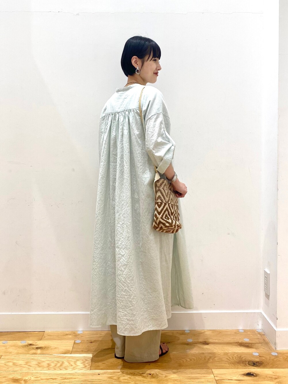 グリーン系のワンピース、ベージュ系のその他パンツ、ブラウン系のショルダーバッグを着用したレディースの夏コーディネートの3枚目の写真