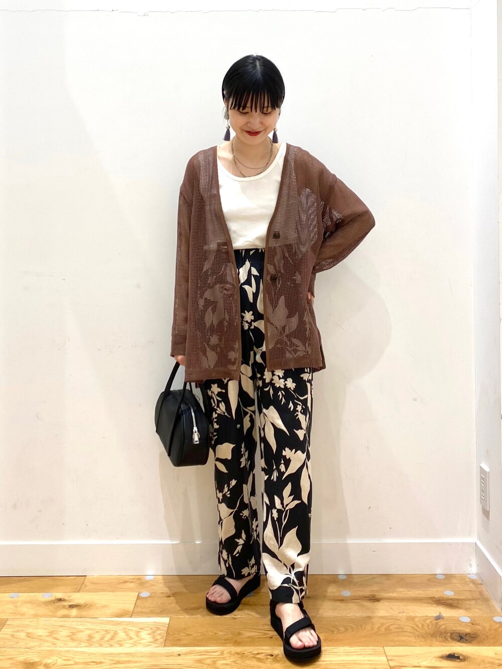 ブラウン系のカーディガン/ボレロ、ホワイト系のタンクトップ、ブラック系のその他パンツを着用したレディースの春コーディネートの2枚目の写真