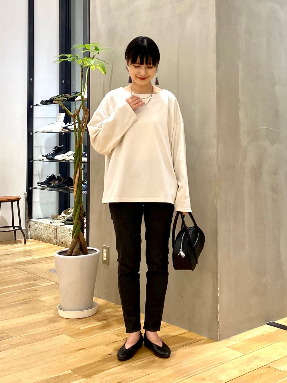 ホワイト系のTシャツ/カットソー、ブラック系のデニムパンツ、ブラック系のショルダーバッグを着用したレディースの秋コーディネートの3枚目の写真