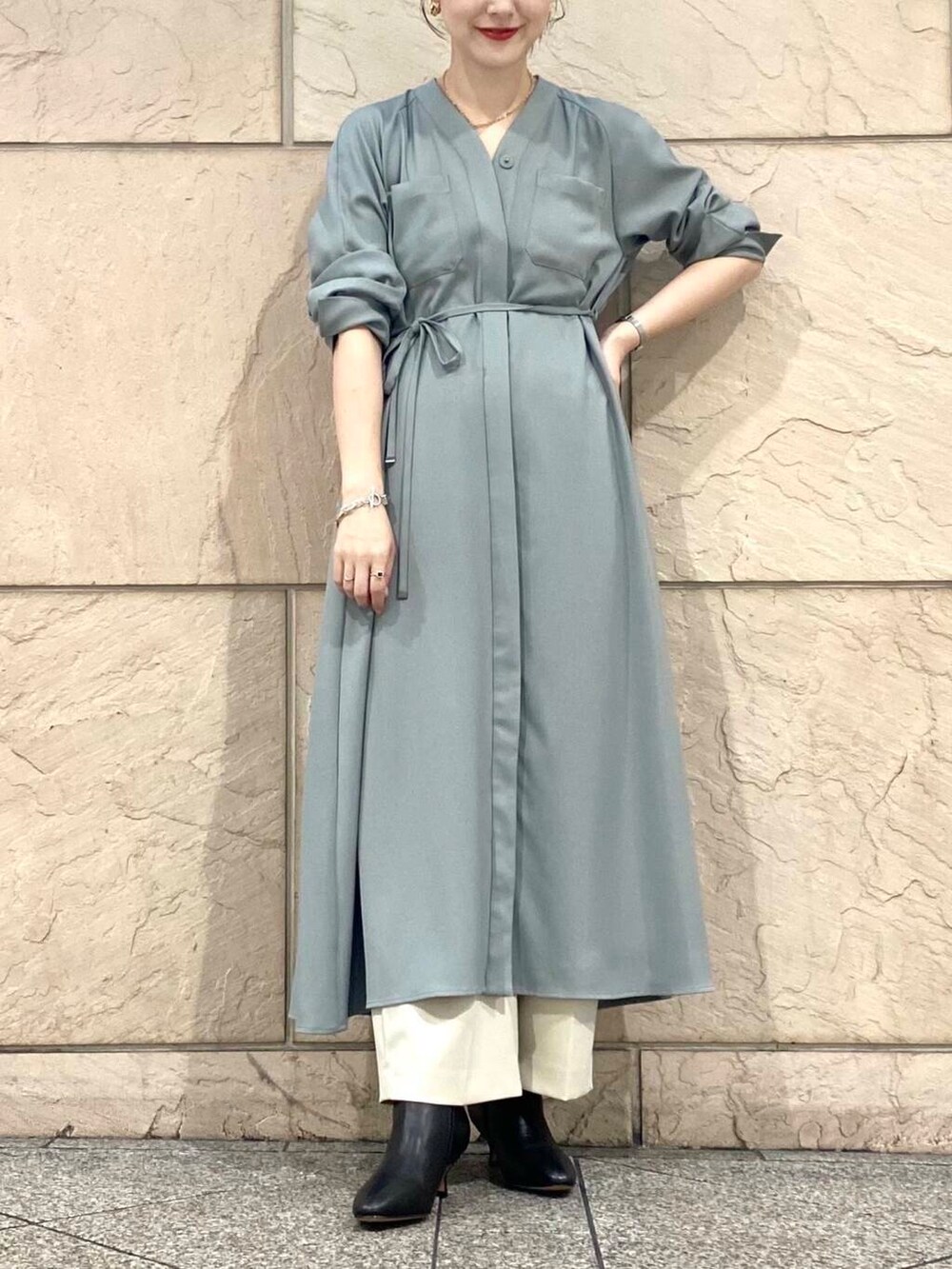 グリーン系のワンピース、ベージュ系のその他パンツ、ブラック系のブーツを着用したレディースの秋コーディネートの5枚目の写真