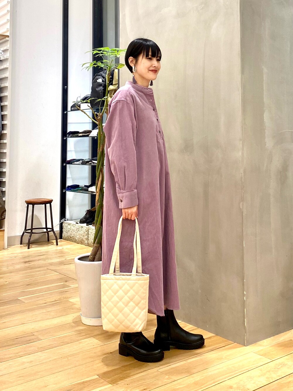 ブラック系のダウンジャケット/コート、パープル系のワンピース、ホワイト系のトートバッグを着用したレディースの冬コーディネートの4枚目の写真