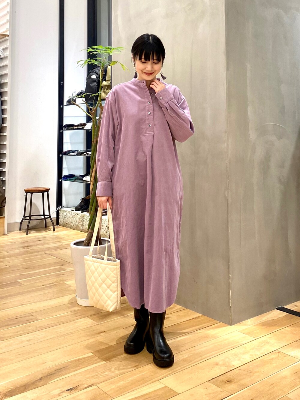 ブラック系のダウンジャケット/コート、パープル系のワンピース、ホワイト系のトートバッグを着用したレディースの冬コーディネートの3枚目の写真