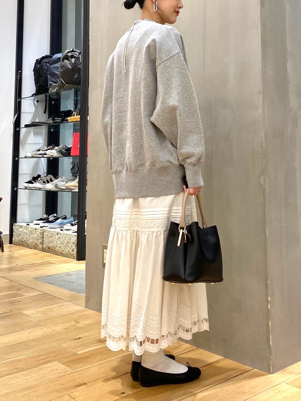 グレー系のTシャツ/カットソー、ホワイト系のスカート、ブラック系のショルダーバッグを着用したレディースの春コーディネートの4枚目の写真