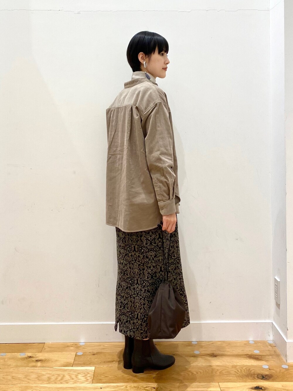 ベージュ系のシャツ/ブラウス、グレー系のTシャツ/カットソー、ブラック系のスカートを着用したレディースの秋コーディネートの3枚目の写真