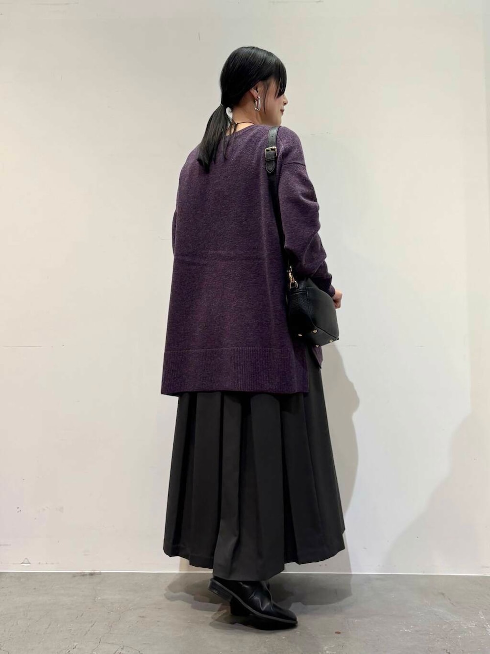 ブラック系のショルダーバッグ、グレー系のスカート、ブラック系のブーツを着用したレディースの冬コーディネートの6枚目の写真