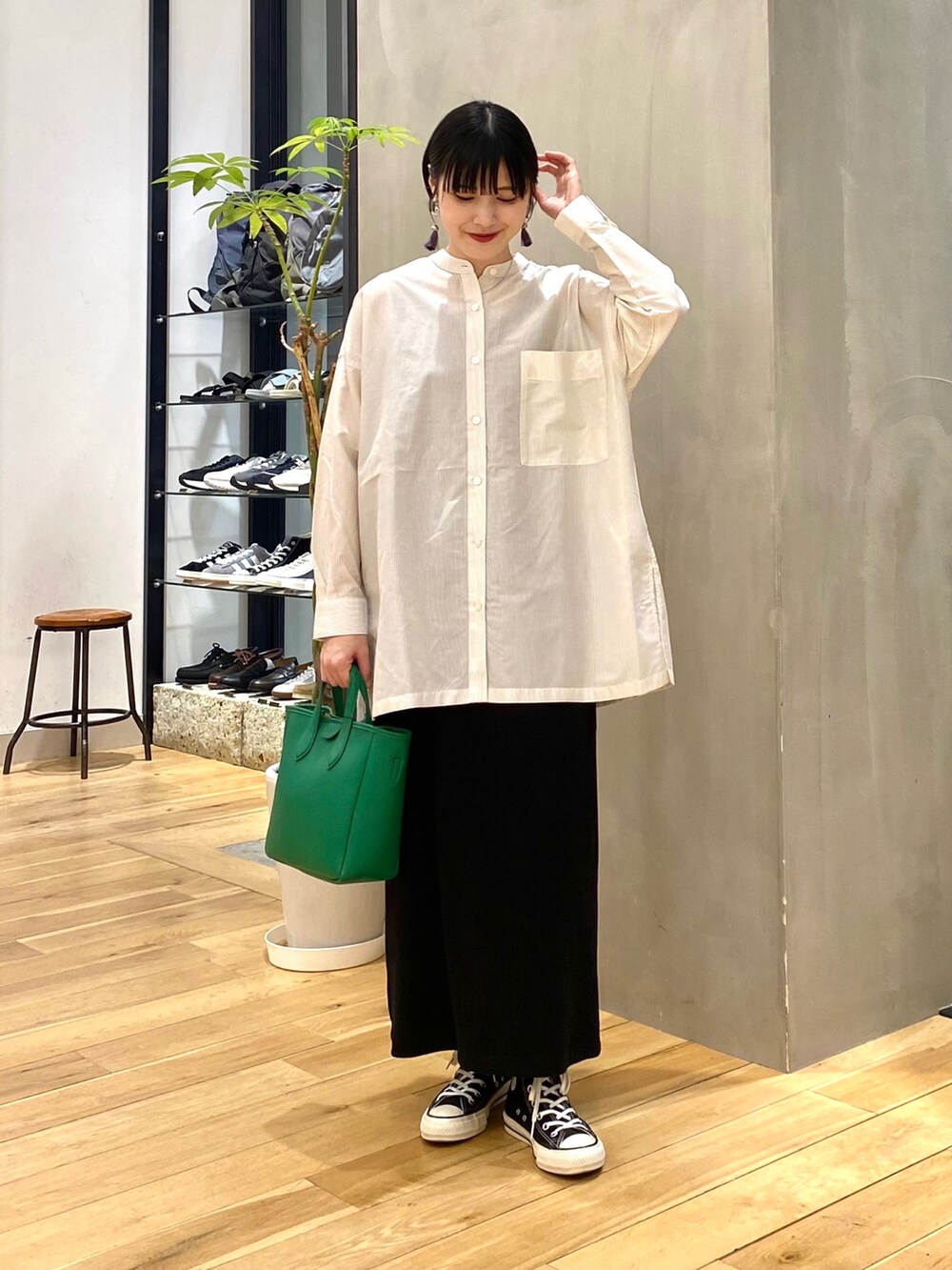 ホワイト系のシャツ/ブラウス、ブラック系のスカート、ブラック系のスニーカーを着用したレディースの春コーディネートの2枚目の写真