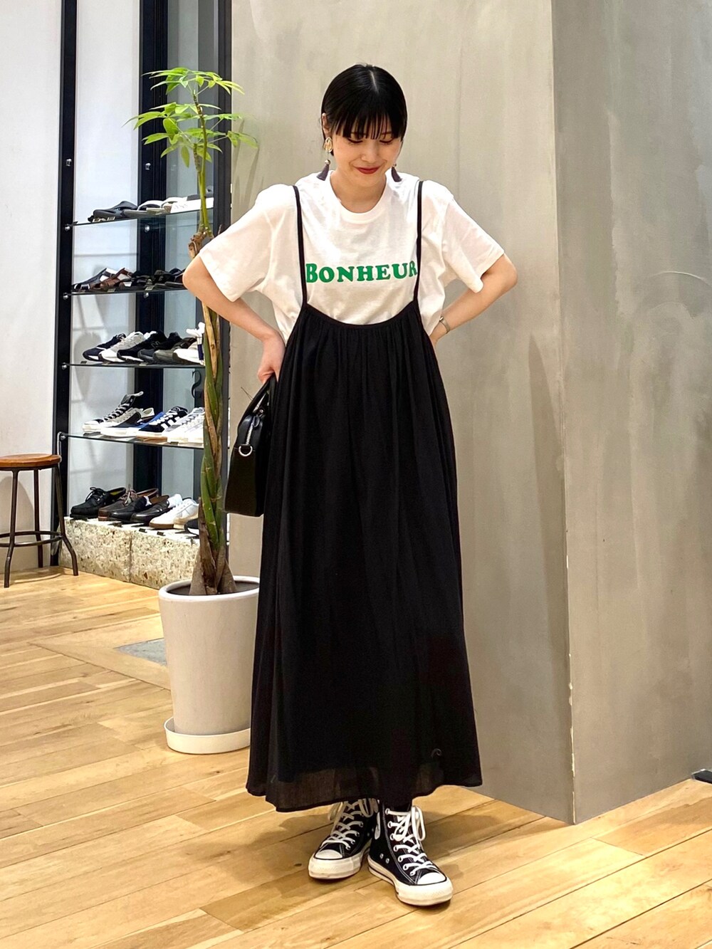 ブラック系のワンピース、ブラック系のショルダーバッグ、ブラック系のスニーカーを着用したレディースの春コーディネートの2枚目の写真